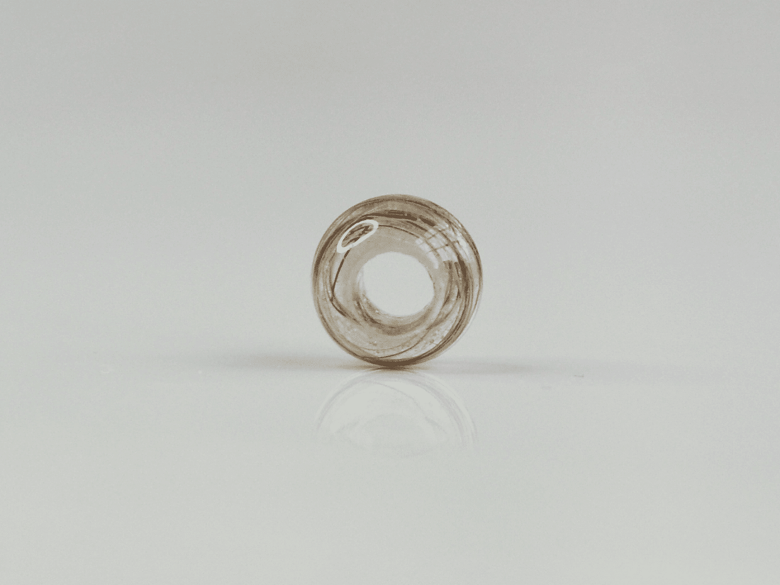 Thea bead — a handmade resin bead with hair wound inside it, shown without a chain